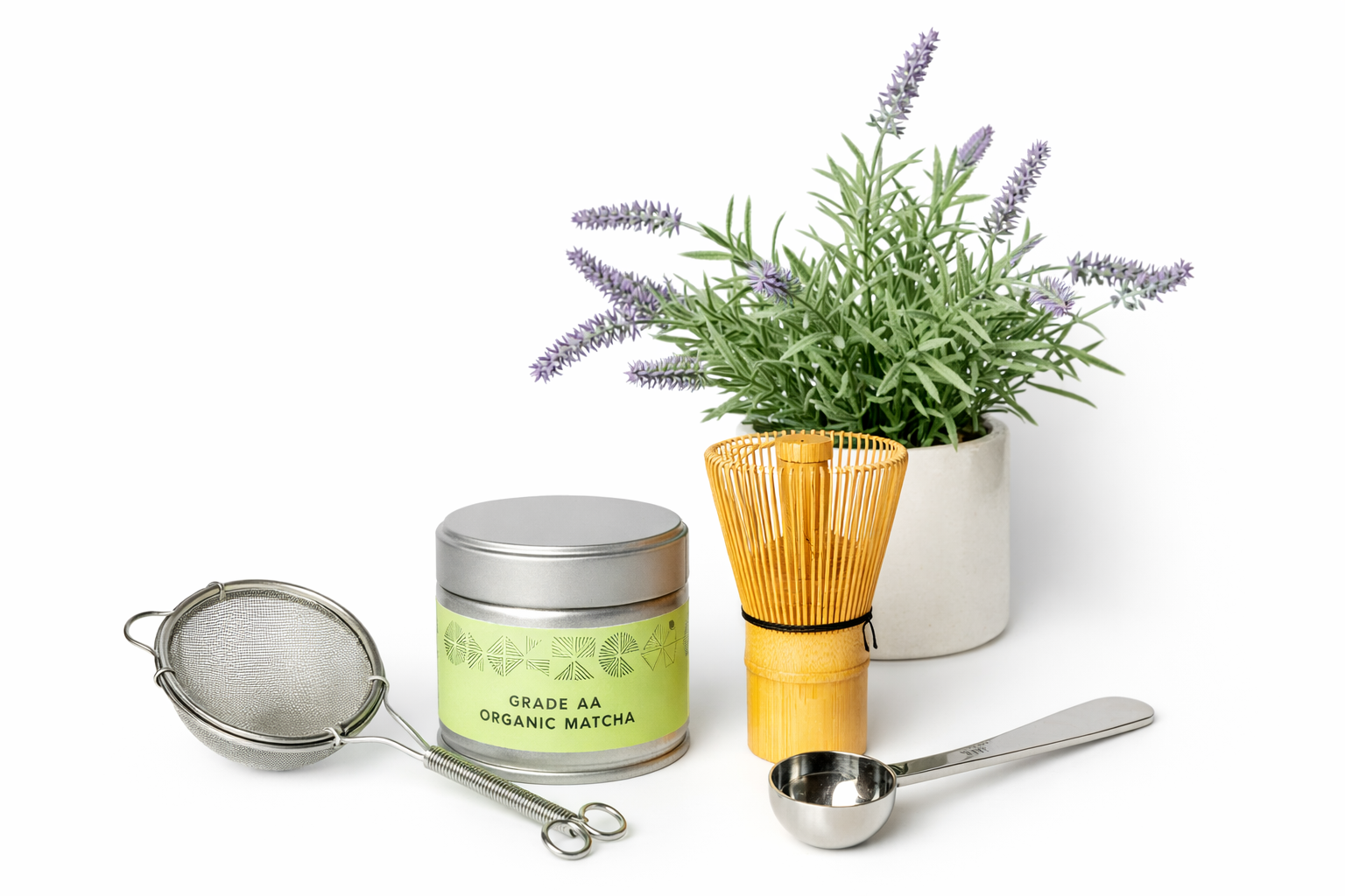 Matcha tea set with a canister, whisk, and spoon on a white background