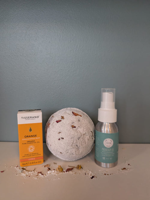 Bath bomb, bottle of Tisserand essential oil, magnesium oil
